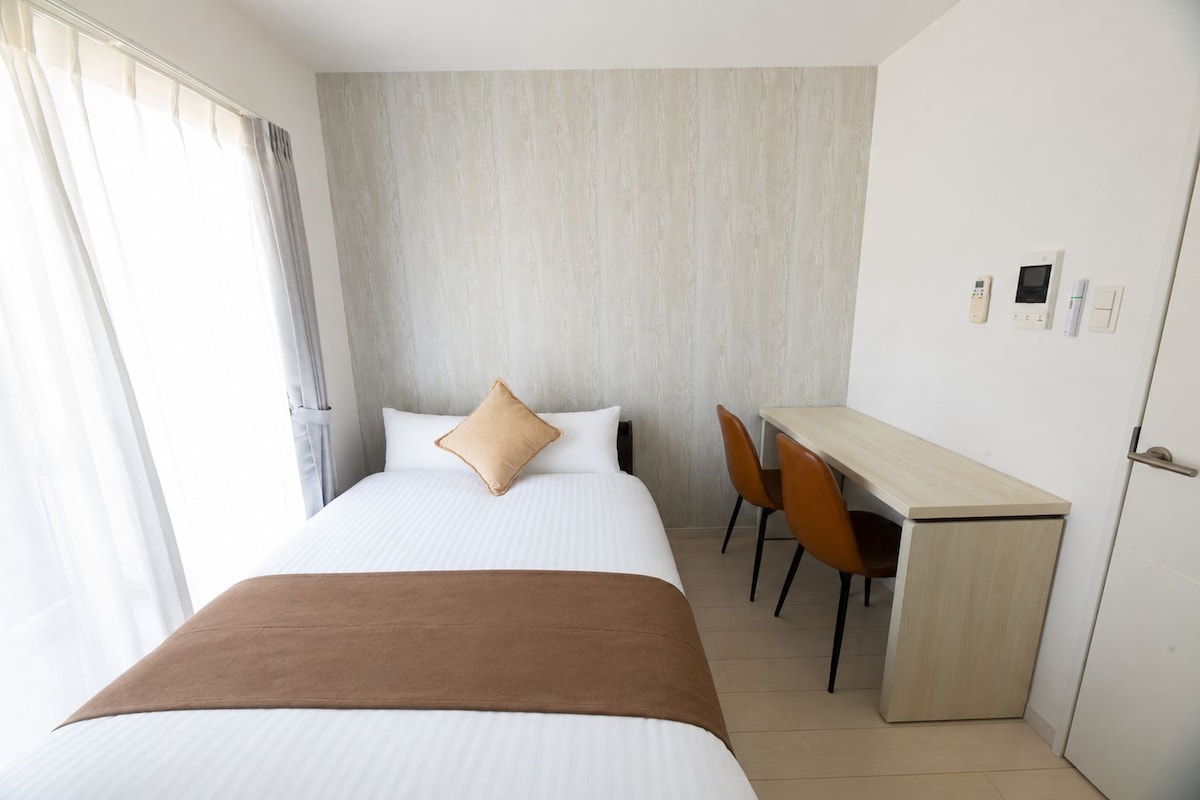 Una habitación de hotel con una cama, un escritorio y sillas.