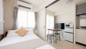 A hotel room with a bed, a desk, a TV, and a kitchenette. - Shrine Side Kego Forest (Fukuoka City Chuoku Kego)