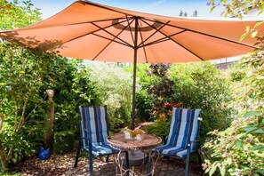 An outdoor seating area with two chairs and a table under a large umbrella. - Holiday apartment in Königheim with barbecue (Königheim)