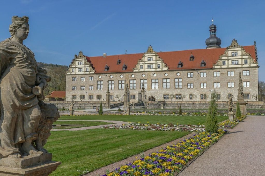 Ein stattliches Gebäude mit einer symmetrischen Fassade, großen Fenstern und einer zentralen Kuppel.