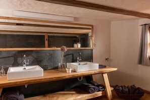 Ein Badezimmer mit zwei Waschbecken, einem Spiegel und einem Holzbadschrank.