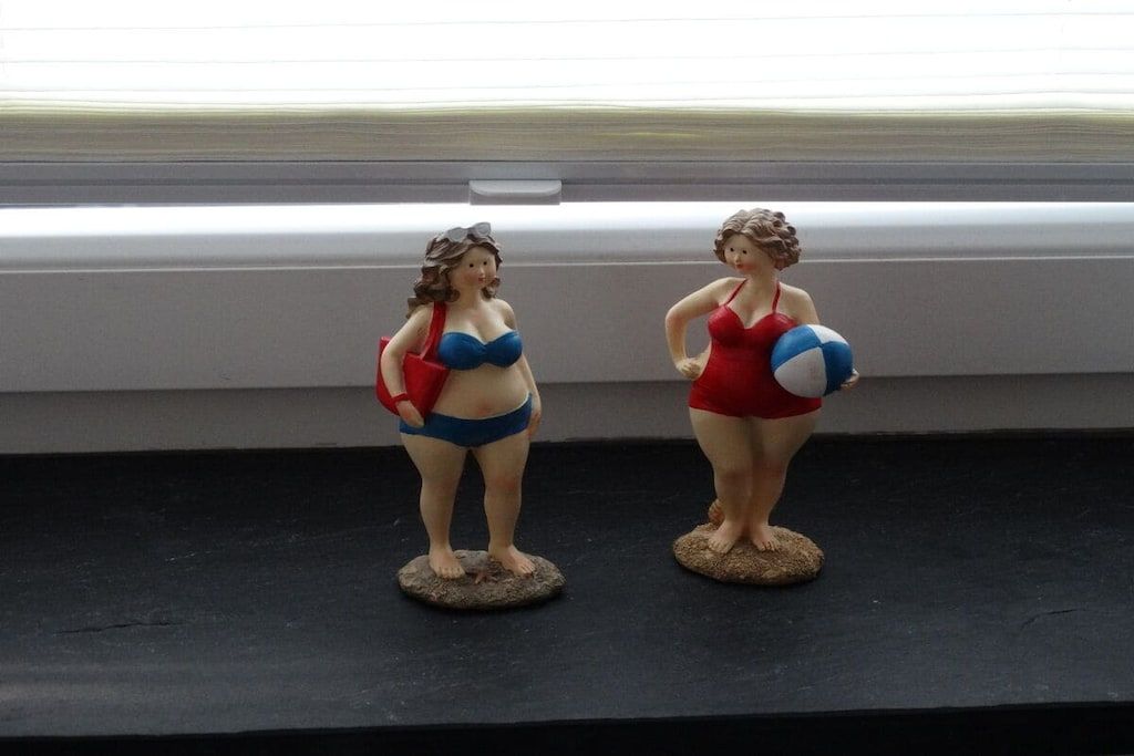 Two figurines on a black surface.
