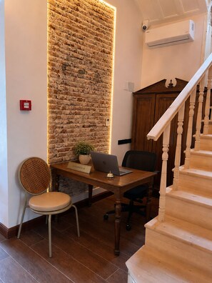 A reception desk with a laptop, a chair, and a potted plant. - CUNDA KONAĞI (Ayvalik)