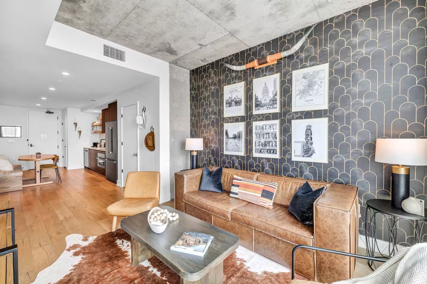 A modern living room with a leather sofa, a coffee table, and a patterned wall.