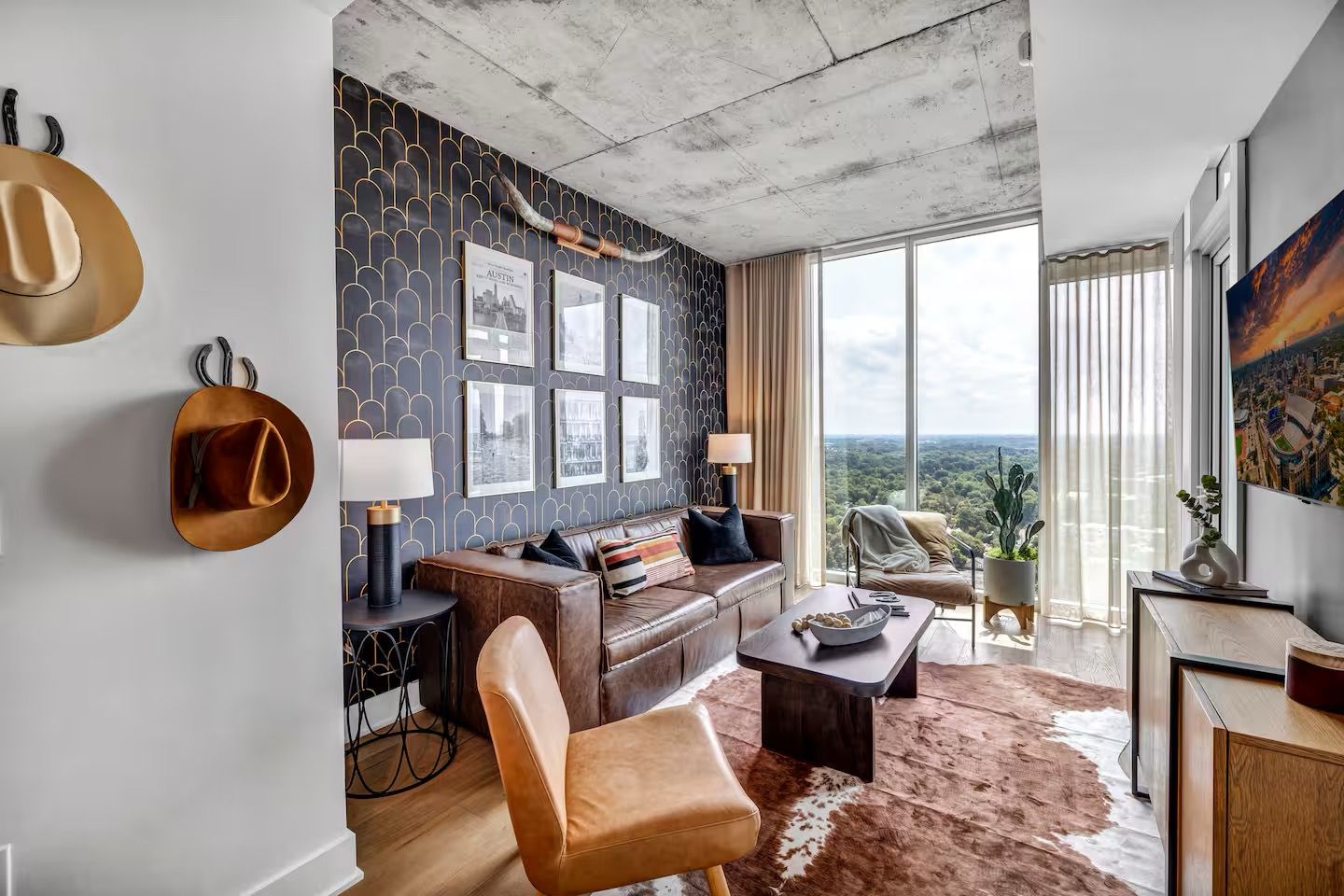 Sala de estar moderna com sofá de couro, mesa de centro e vista da cidade através de grandes janelas.