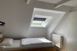 A small, single-bed room with a sloped ceiling and a skylight. - Holiday home in Varel with swimming pool (Varel)