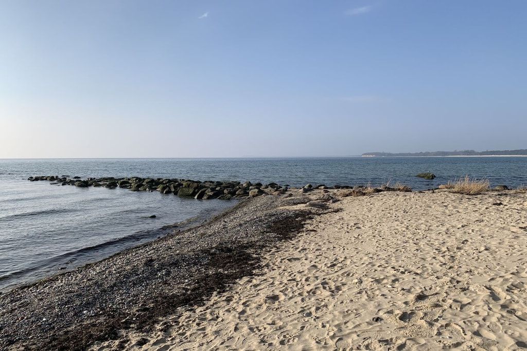 Een strand met een rotsachtige kustlijn en een zandgebied.