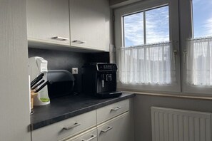 A small kitchenette with a coffee maker, a toaster, and a cabinet. - Holiday home in Varel-Dangast with Wi-Fi (Varel-Dangast)