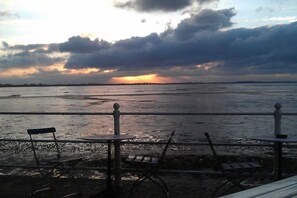 A seaside view with a railing, a bench, and a table. - Holiday home in Dangast with swimming pool (Dangast)