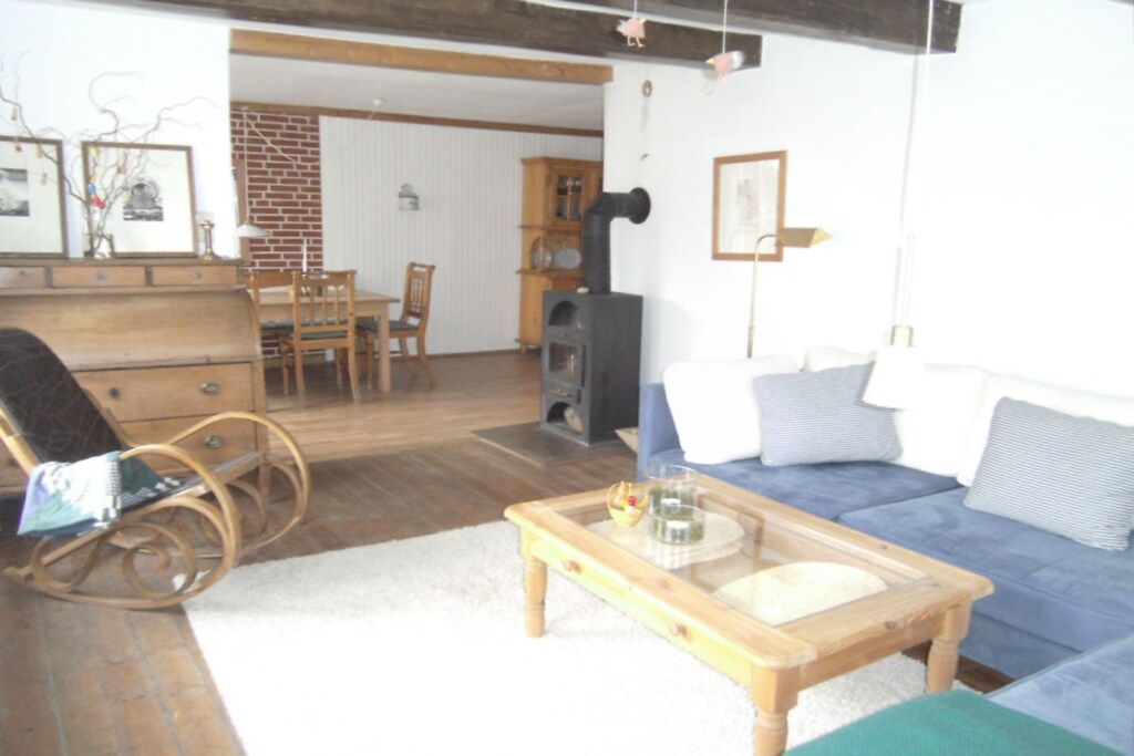 A living room with a sofa, a rocking chair, a coffee table, and a fireplace.