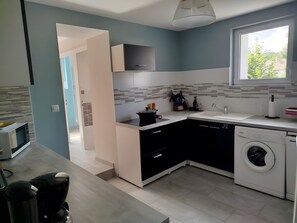 A modern kitchen with a microwave, sink, and washing machine.