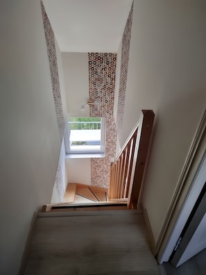 A staircase with a patterned wall and a window at the top. - Gîte Le Petit Buis: Mountain Views, Private Terraces & Wi-Fi (Chissey en Morvan)