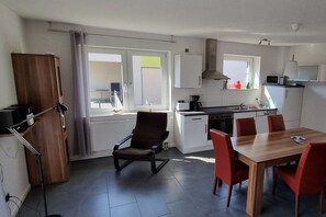 A modern kitchen with a dining area, including a table and chairs, a chair, and a cabinet. - Wismar cog starboard (Zierow)
