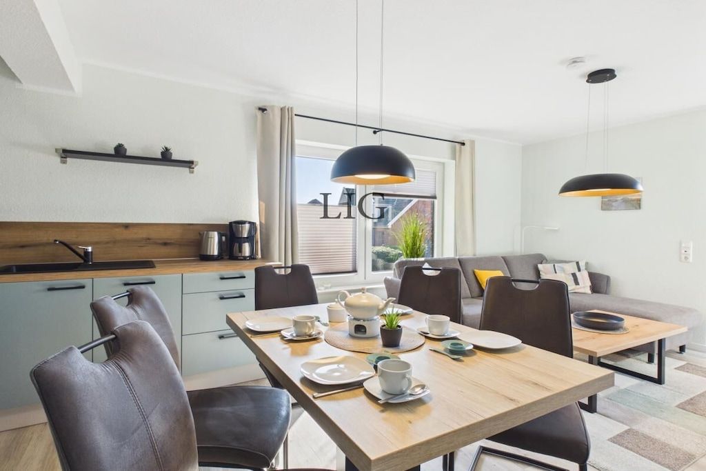 Ett modernt kök med matplats, en soffa och ett fönster med utsikt.