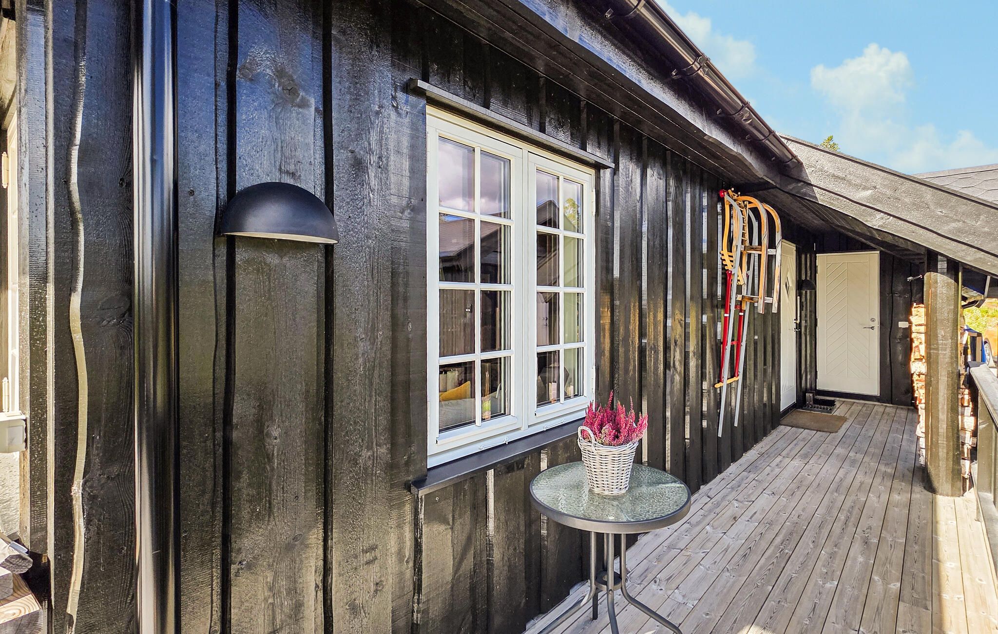 A wooden building with a window, a table with a basket, and a door.