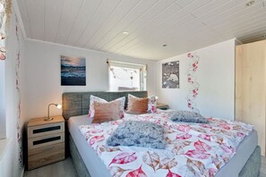 Een slaapkamer met een bed, nachtkastjes en kunst aan de wanden.