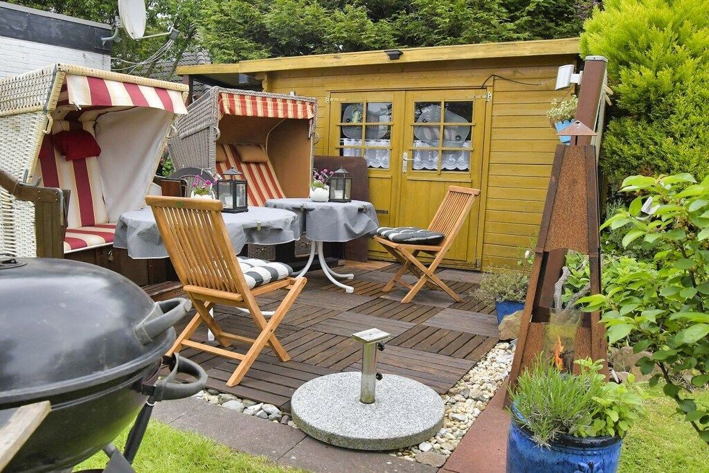 Une terrasse avec des meubles d’extérieur, un barbecue et une petite table.