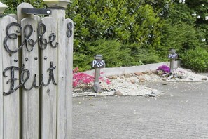 A wooden fence with metal letters spelling 'Elbe Flut' and two lantern-style signs with the same text. - Holiday apartment with 2 bedrooms (Büsumer Deichhausen)