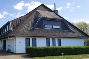 Una casa de un piso con techo a dos aguas, una chimenea y el número 8 en el lateral.