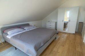 Ein Schlafzimmer mit einem Bett, einem Kleiderschrank und einem Nachttisch.