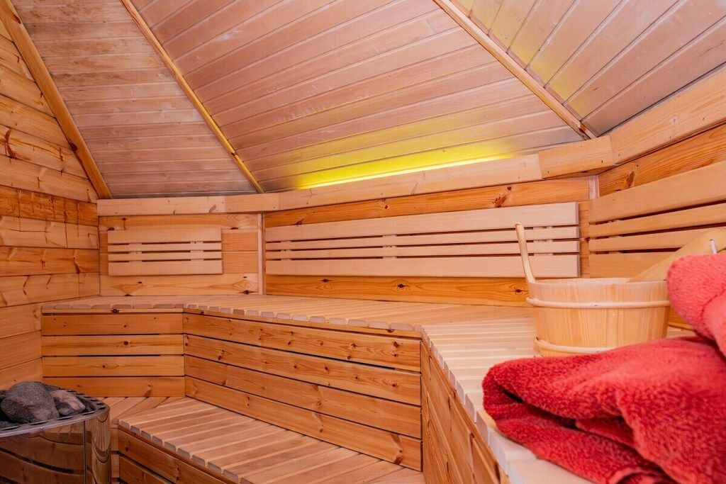 A sauna with wooden benches and a bench with a towel.
