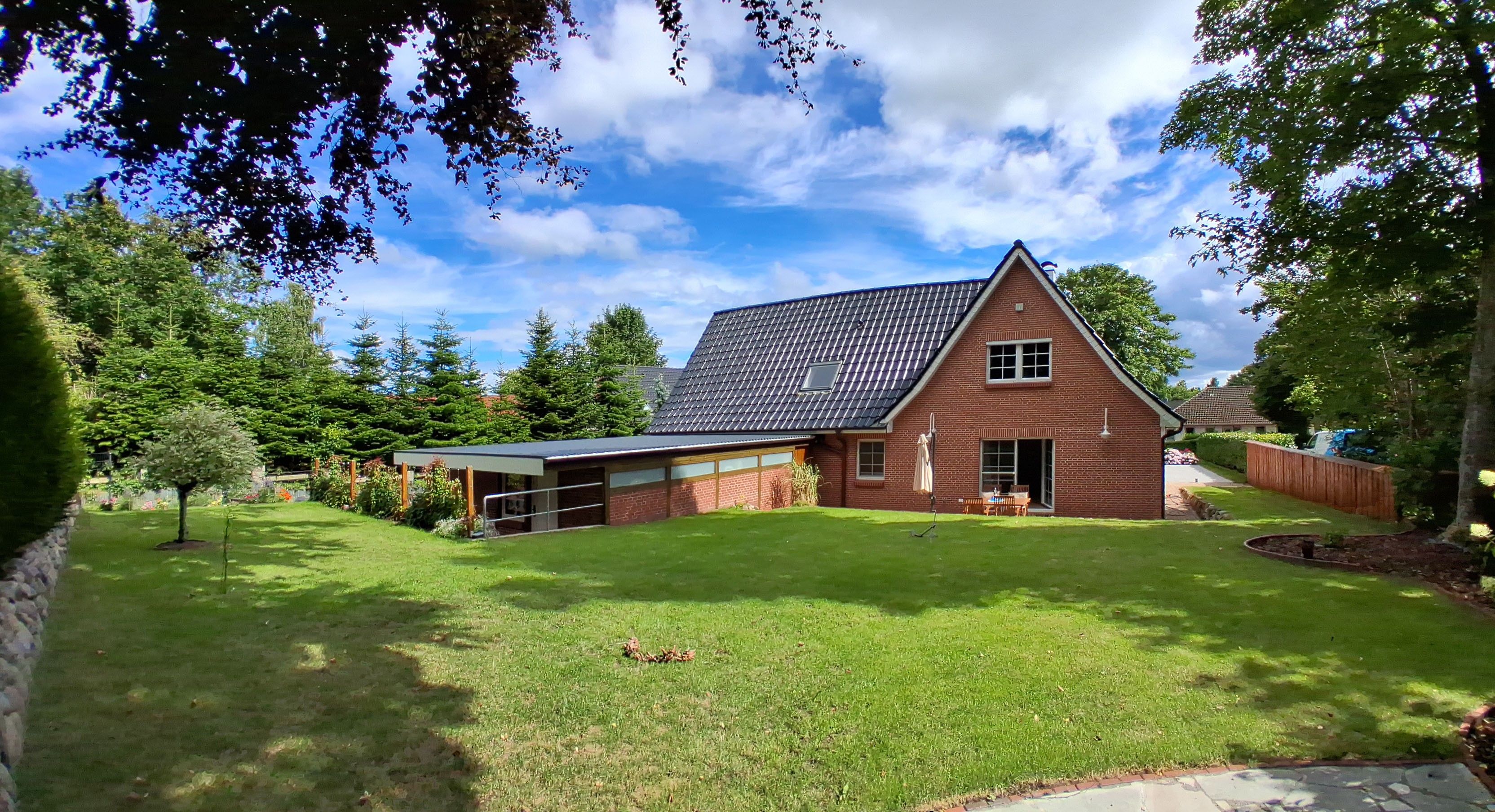 A house with a sloped roof, a garage, and a well-maintained lawn.