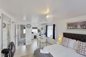 A modern hotel room with a bed, a desk, and a kitchenette. - Apartment 203 - Symons House (Medway)