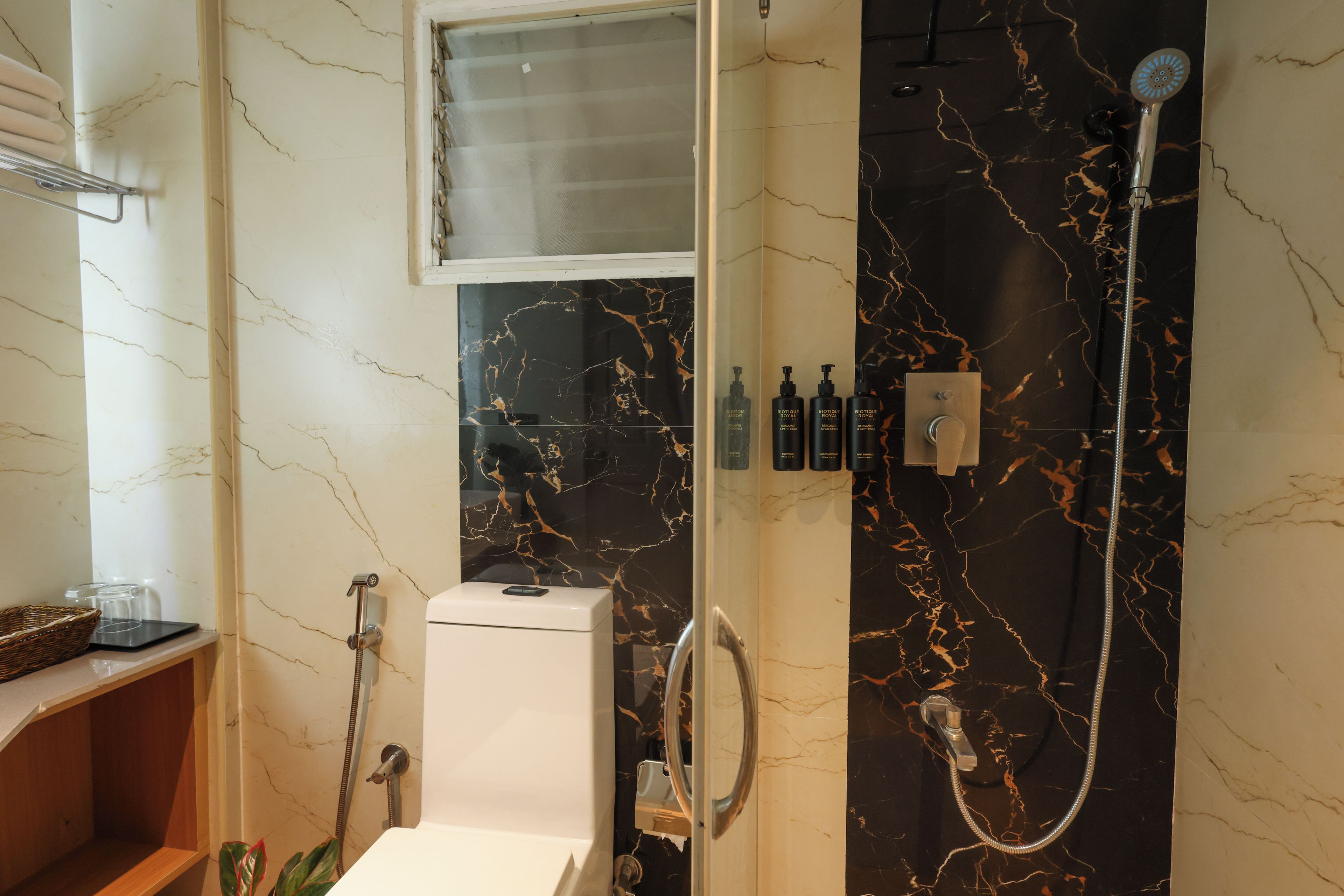 A bathroom with a shower, toilet, and a vanity with a mirror.