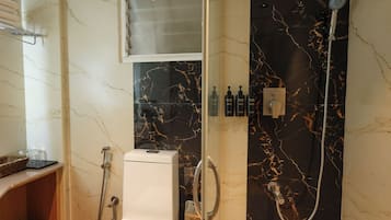 Un baño con ducha, inodoro y tocador con espejo.