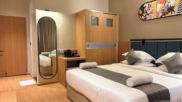Een hotelkamer met een bed, nachtkastje en een spiegel.