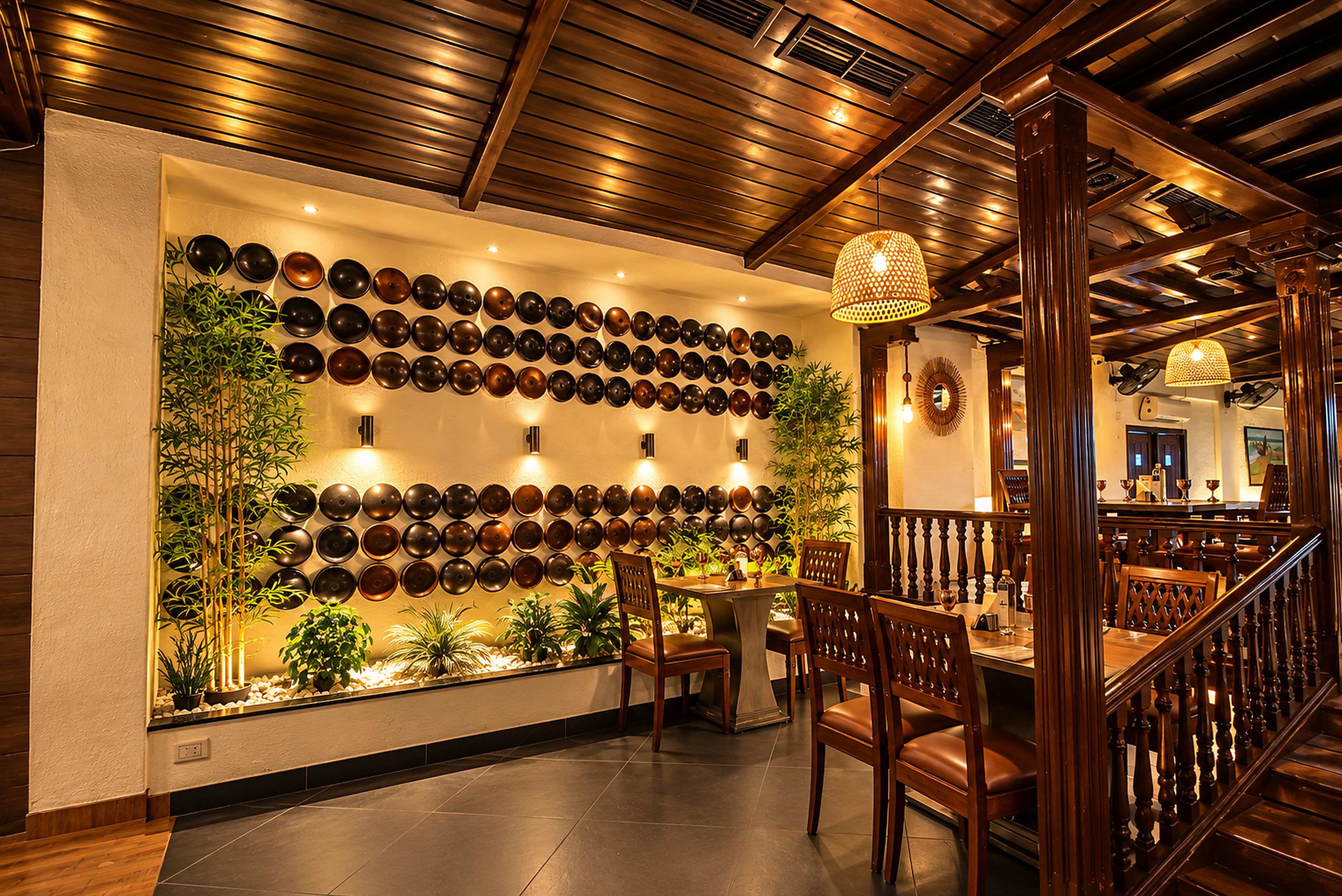 A restaurant interior with a wall of decorative plates, wooden ceiling beams, and a staircase.