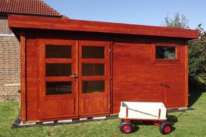 Un bâtiment en bois doté de grandes portes vitrées et d’une petite fenêtre.