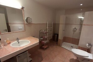 Kylpyhuone, jossa on pesuallas, peili, pyyheteline, suihku ja wc.