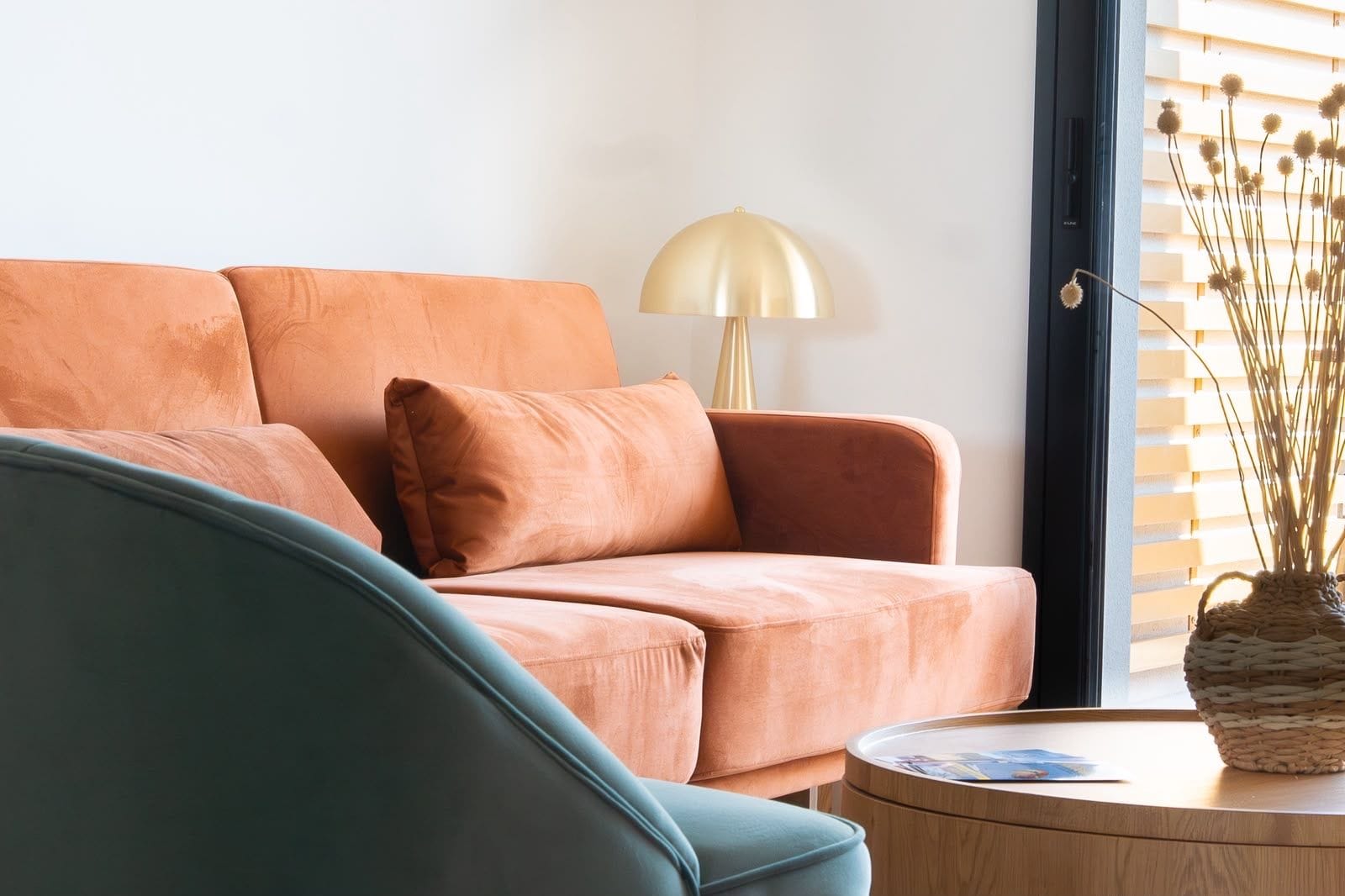 Una sala de estar con un sofá, una lámpara y una mesa con una cesta.