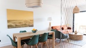 Un comedor con una mesa y sillas de madera, un cuenco de fruta y un cuadro en la pared.