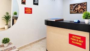 A reception area with a black counter, a red sign stating 'OUTSIDE FOOD IS NOT ALLOWED', and a wall-mounted air conditioning unit.