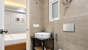 A modern bathroom with a toilet, sink, and shower.