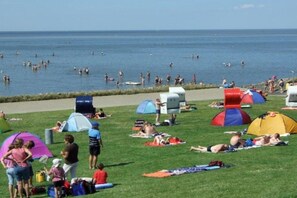 Ein Strand mit Zelten und Menschen, die in der Sonne baden.