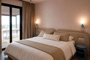 A hotel room with a large bed, two bedside lamps, a view through a sliding door, and a small round table. - Penthouse · 100 m² terrace · Jacuzzi (Saranda)