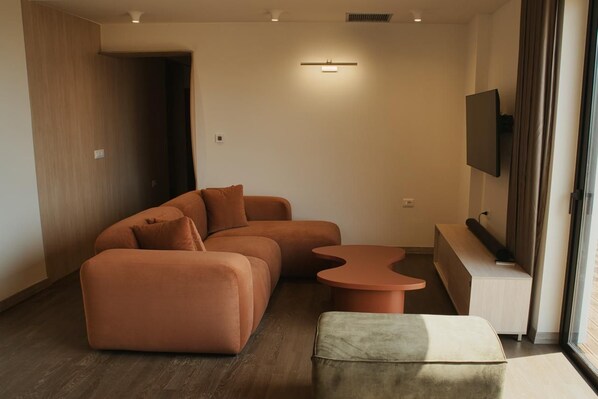A modern living room with a sectional sofa, a small coffee table, and a bench. - Penthouse · 100 m² terrace · Jacuzzi (Saranda)