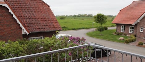 Et boligområde med murstenshuse, en belagt indkørsel og en græsplæne i baggrunden.