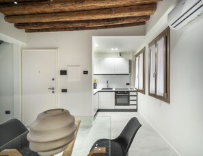 A modern kitchen with white cabinets, a built-in oven, and a wooden ceiling. - Cà Delle Navi Apartment R&R (Venice)