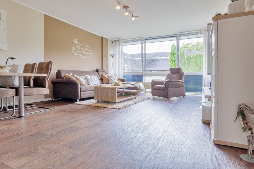 A modern living room with a sofa set, a coffee table, and a dining area with chairs.