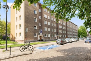 A multi-story residential building with a parking area and a bicycle parked outside. - Apartament Tamara by Q4 Apartments  (Gdańsk)