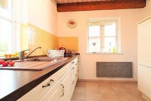 A kitchen with a sink, countertop, and window. - Holiday home with 2 bedrooms (Gross Schwansee)