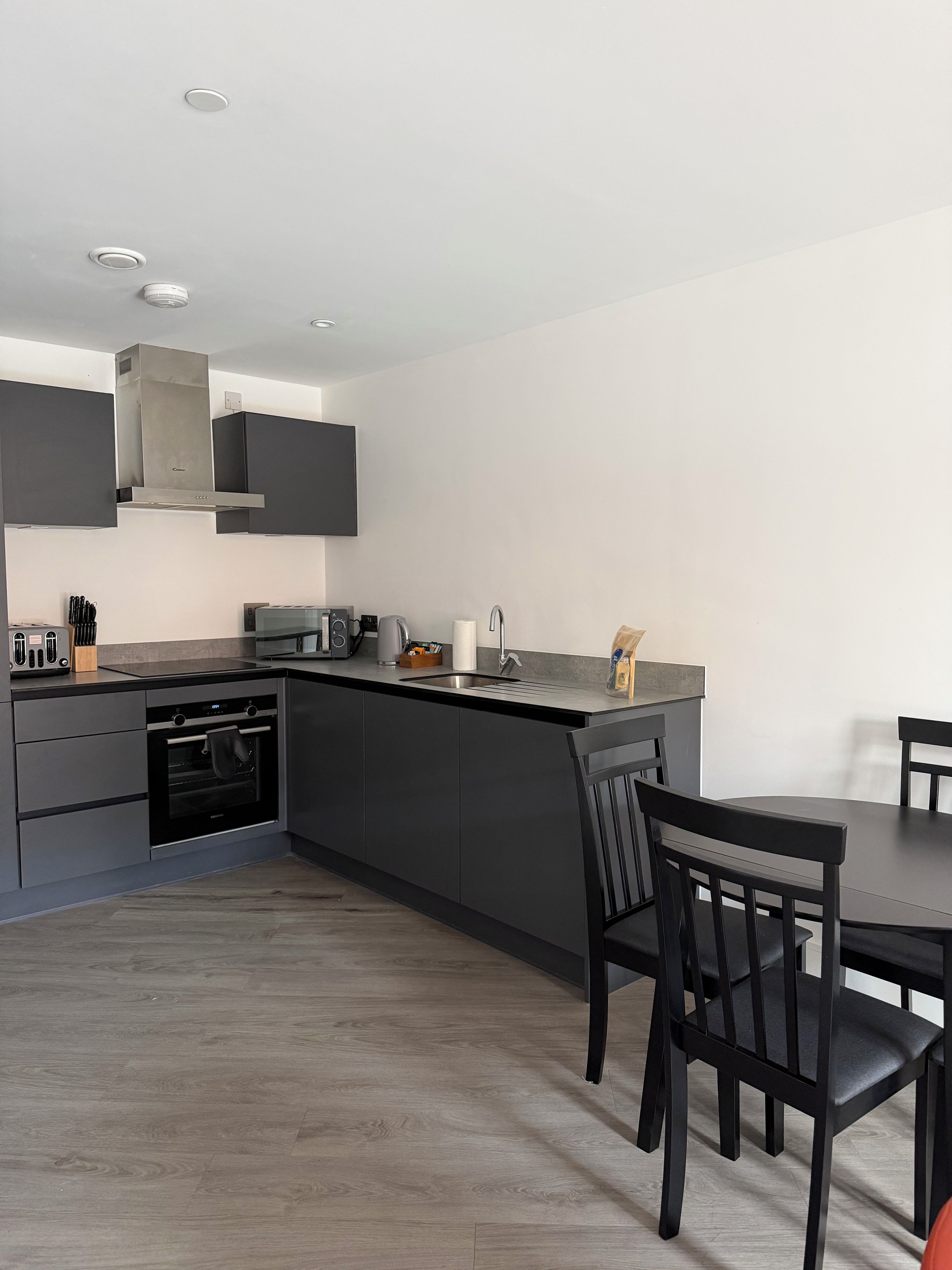 A modern kitchen with a built-in oven, a microwave, and a coffee maker.