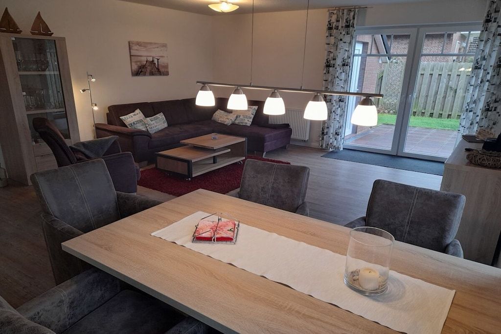 Een moderne woonkamer met een bank, salontafel en eethoek.