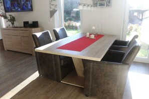 A dining area with a table, chairs, and a red placemat. - Holiday home with 4 bedrooms (Hooksiel Wangerland)