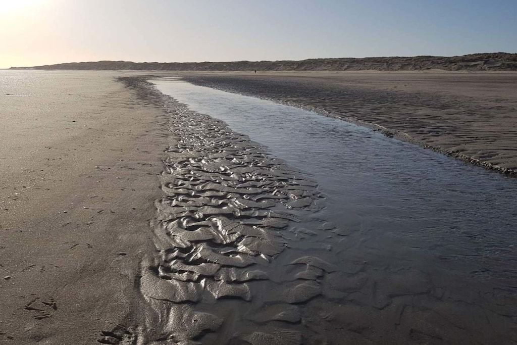 A beach with a water channel running through it.