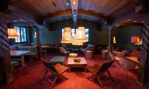 Ein gemütliches Blockhaus-Interieur mit Essbereich, Sitzgelegenheiten und Hängeleuchten.